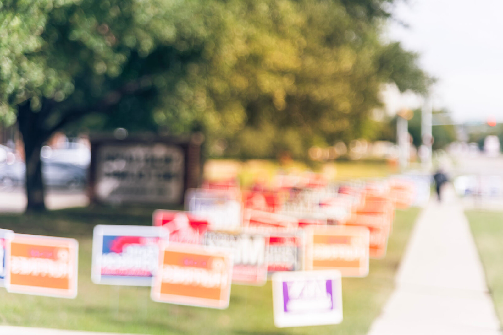 Group of custom signs in the grass by a tree